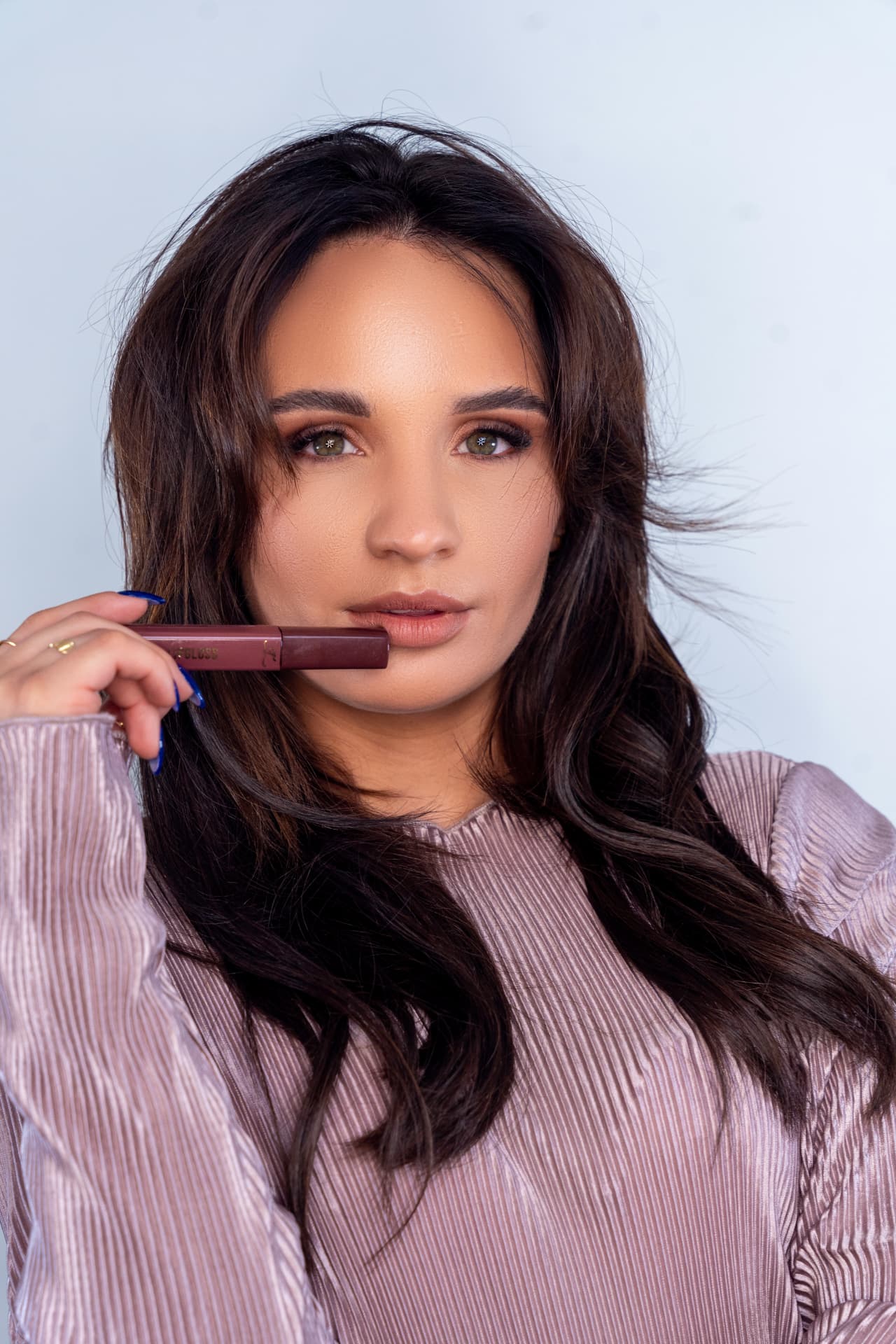 Model holding a matte lip gloss wand